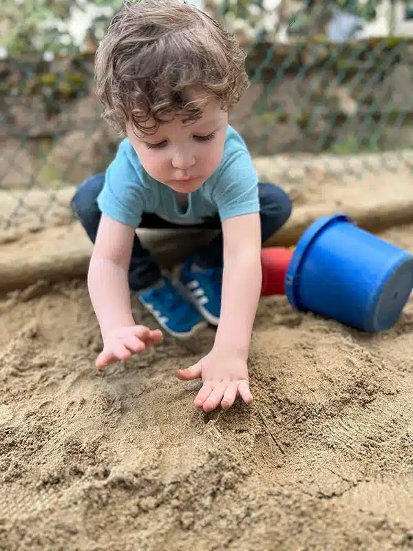 Child playing in sand at Scribbletime