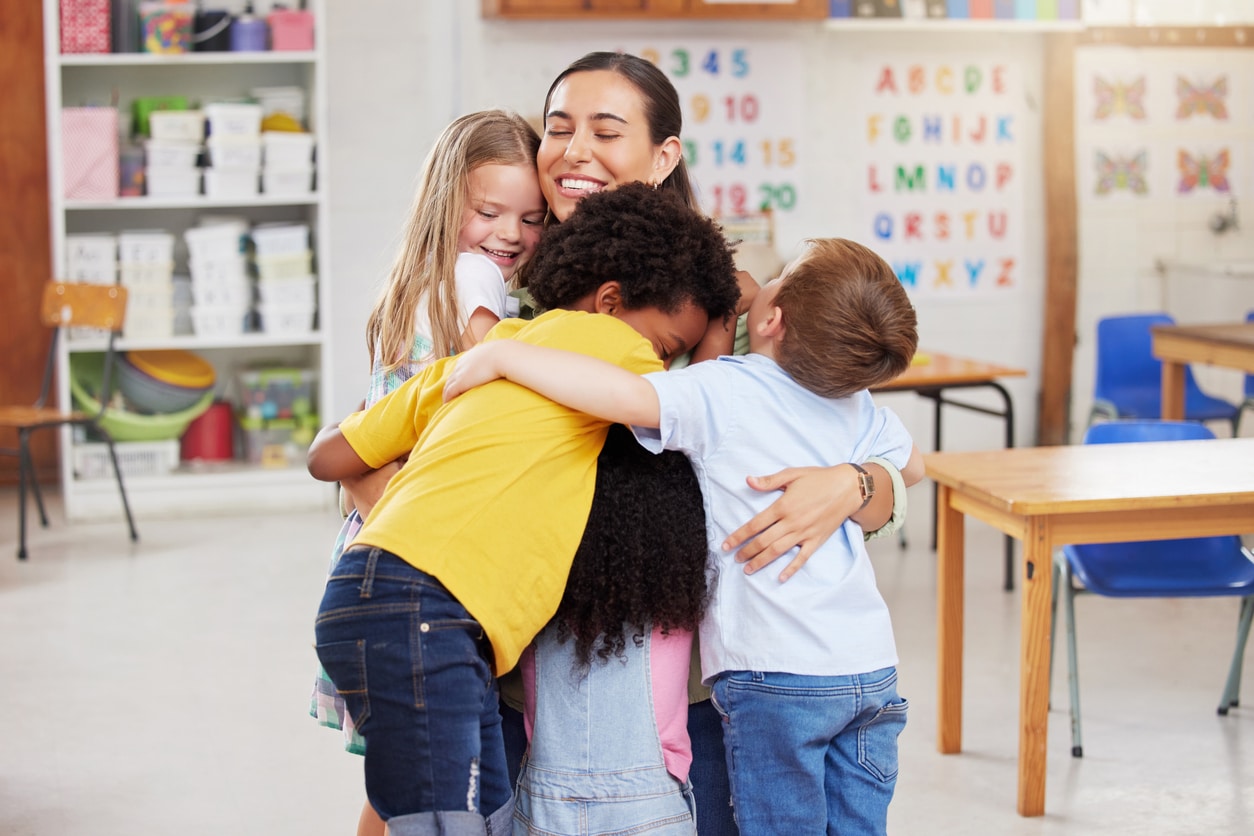 childcare center teacher hugging students
